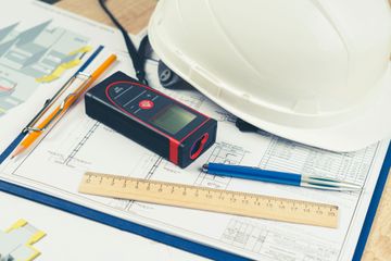 helmet and tools for construction drawings and construction drawings and laser rangefinder for distance measurements, close-up, selective focus